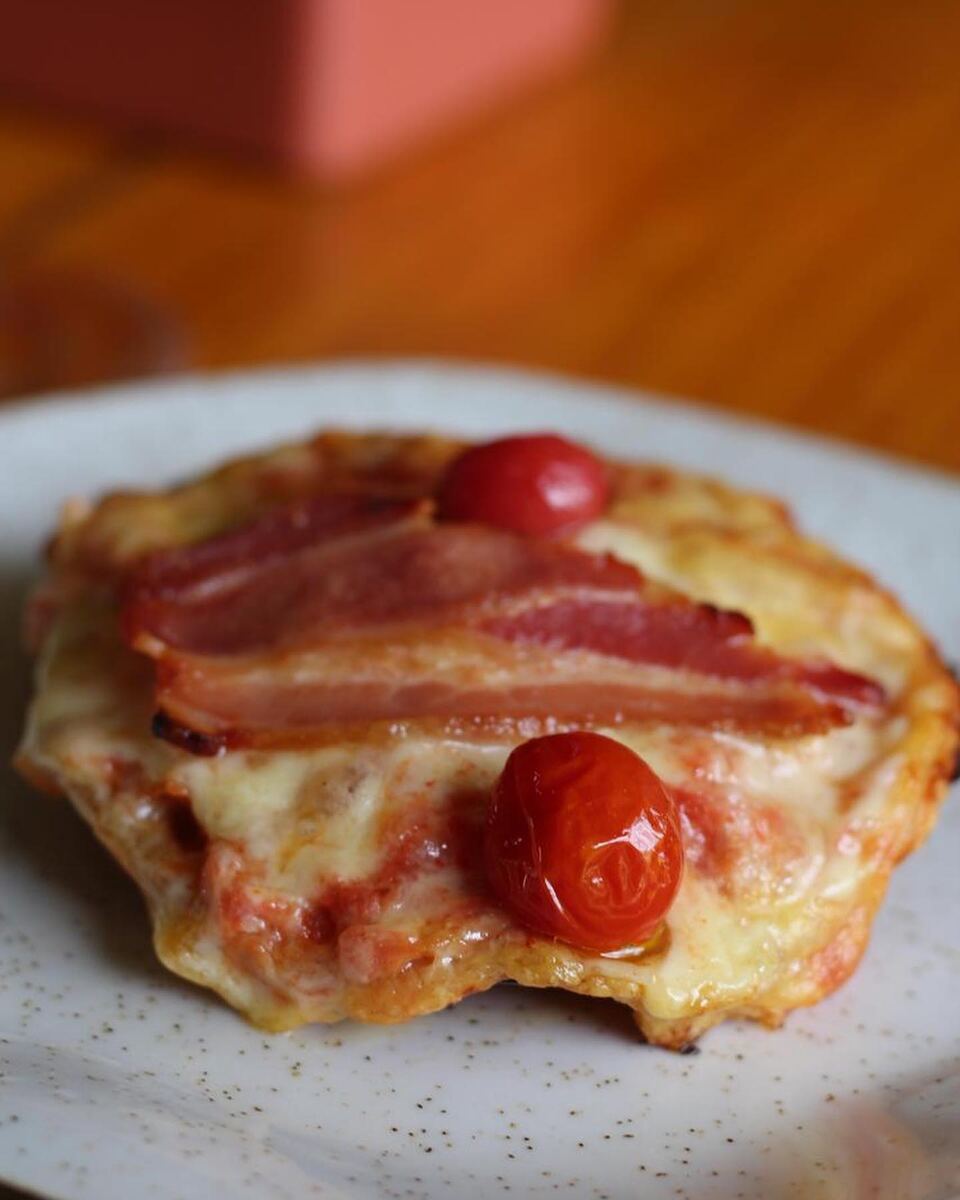 Pizza individual com bacon e tomate-cereja, preparada num curso de gastronomia da casa